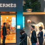 Shoppers wait in line outside a Hermes International store