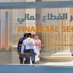 Saudi participants pass by a sign of the Financial Sector Conference held in Riyadh, on April 24, 2019.