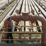 An employee inspects pipes used for landing and unloading crude and refined oil at the North Pier Terminal, operated by Saudi Aramco