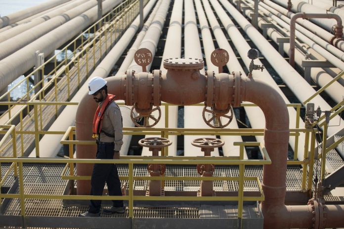 An employee inspects pipes used for landing and unloading crude and refined oil at the North Pier Terminal, operated by Saudi Aramco